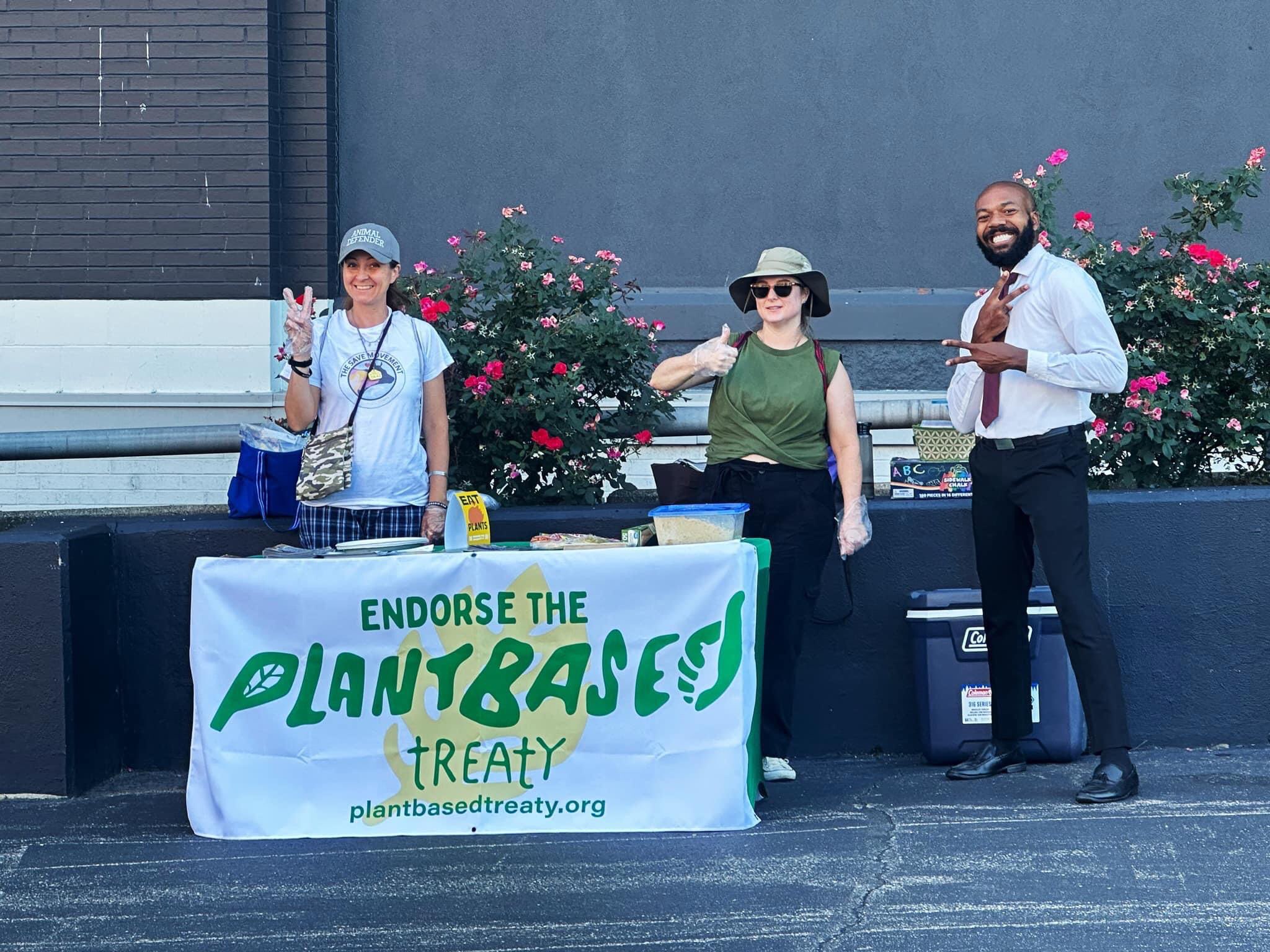 Three people at a banner that says 'Endorse the Plant-Based Treaty'